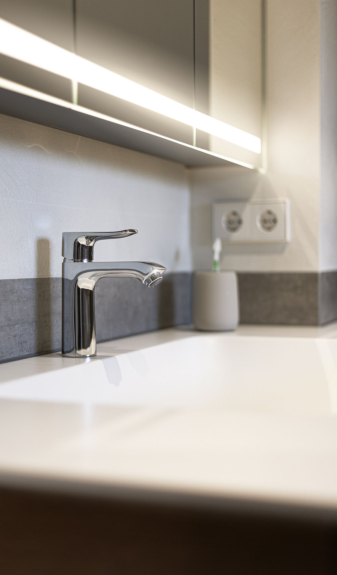 Ein stilvoller Waschplatz mit einer eleganten, verchromten Armatur auf einer weißen CORIAN-Waschtischplatte.