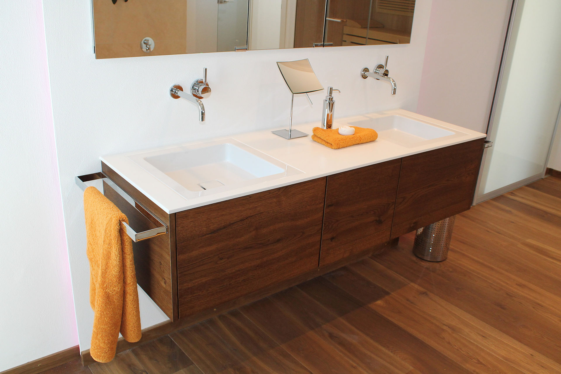 Wandmontiertes Doppelwaschbecken mit stilvollem Holzunterschrank und wandmontierten Armaturen.