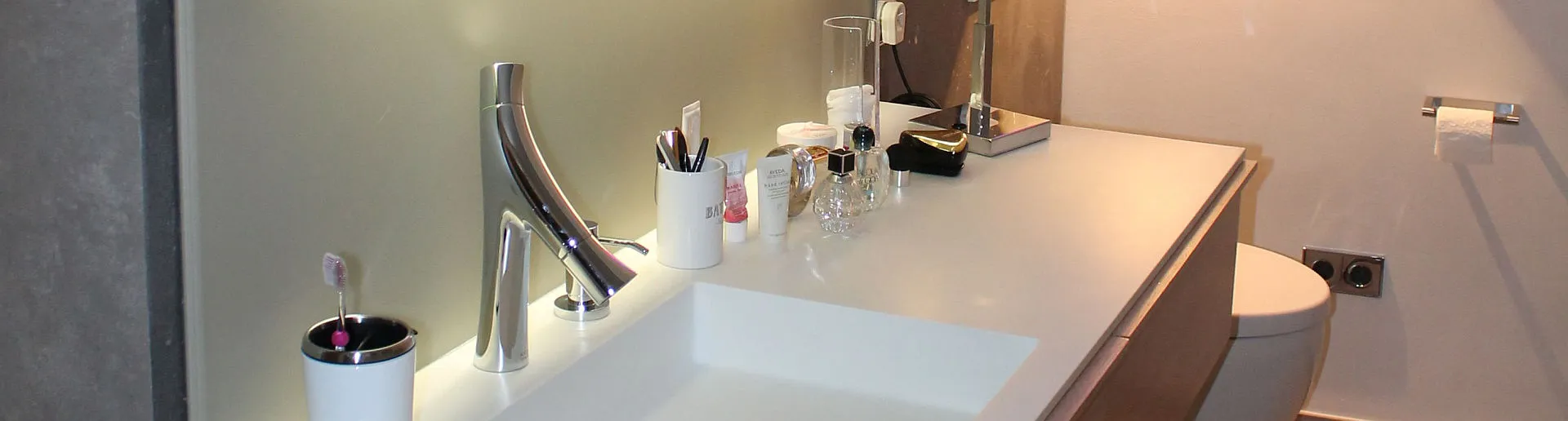 Ein stilvoll eingerichtetes Badezimmer mit einem breiten Waschbecken und einer glänzenden Chromarmatur.