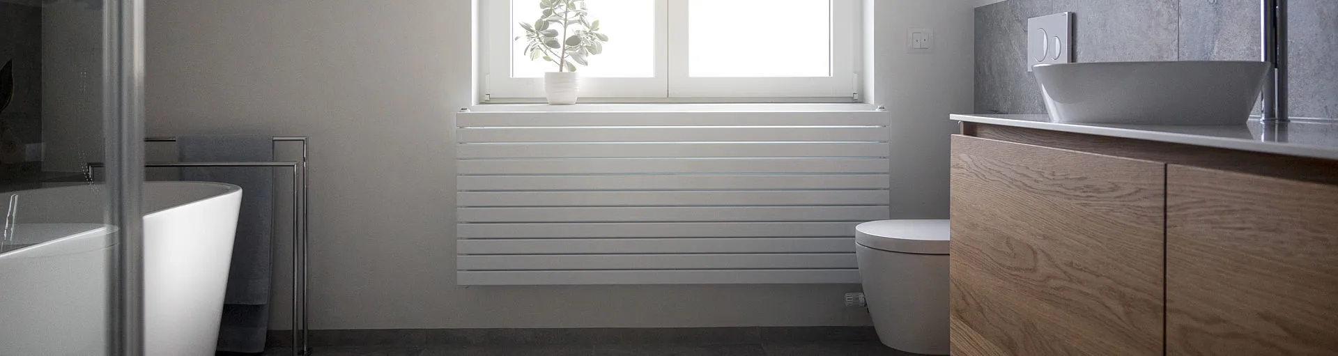 Das helle Dachbadezimmer mit natürlicher Lichtquelle kombiniert klare Linien mit modernen Materialien wie Holz und Keramik. 