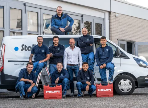 Das Team von Staib vor einem Firmen-Fahrzeug.