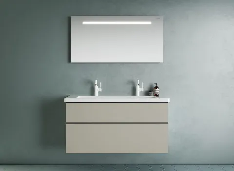 Badezimmer der Burgbad Eqio-Kollektion mit einem schwebenden Waschtisch und zwei Wasserhähnen sowie einem horizontalen LED-Spiegel an der Wand. 