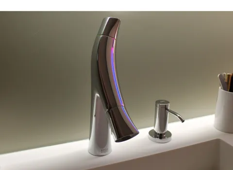 Nahaufnahme eines eleganten Wasserhahns mit geschwungener Form und glänzender Chromoberfläche.