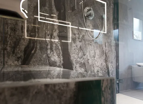 Nahaufnahme einer Dusch-Sitzbank aus Naturstein.