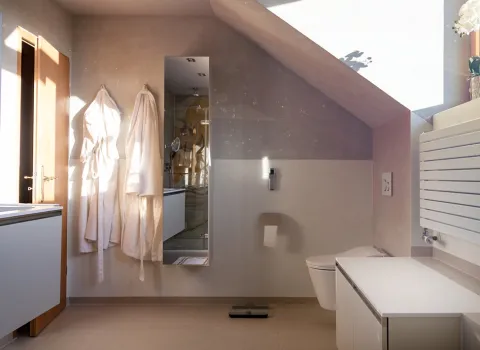 Badezimmer mit Dachschräge, zweifarbige Wand einem Spiegel und Bademäntel