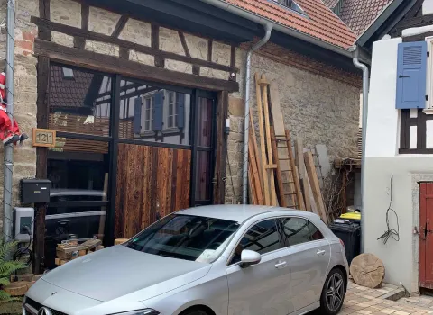 Innenhof mit altem Fachwerkhaus und Auto vor der Installation der Heizungsanlage.