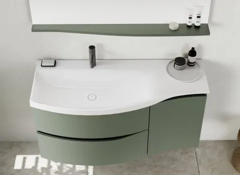 Geschwungener Waschtisch mit großer Ablagefläche auf der linken Seite.