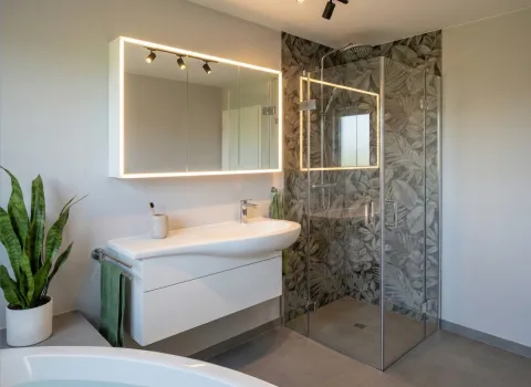 Funktionales Vollbad mit dekorativer Wandgestaltung, Dusche und harmonischem Raumkonzept.