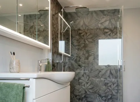 Kompaktes Vollbad mit Stil, Glasdusche mit Deckenbrause, LED-Spiegel und eleganter Waschtisch.