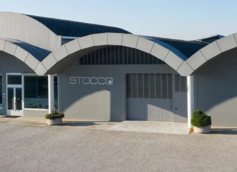 Außenansicht des Firmengebäudes von Stocco mit markanter gewölbter Dacharchitektur und großem Eingangsbereich.