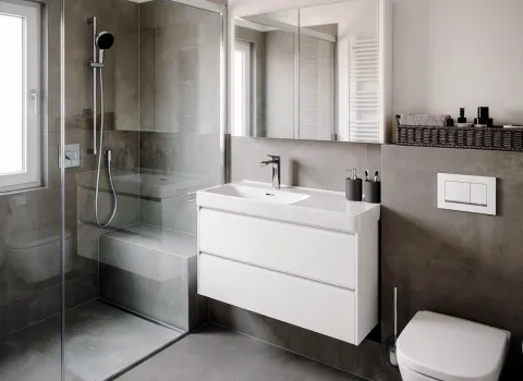 Graues Designbad mit bodengleicher Dusche und Sitzbank