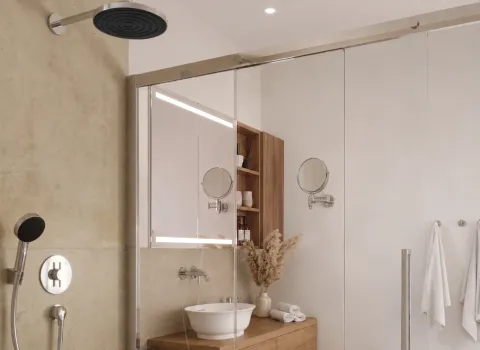 Dusche mit Kopfbrause und Glasabtrennung