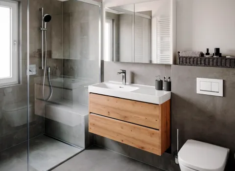Graues Designbad mit bodengleicher Dusche und Sitzbank