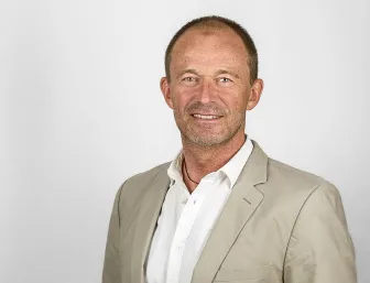 Geschäftsführer Dirk Gebhardt vor grauem Hintergrund.