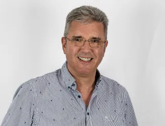 Projektleiter Hartmut Amolsch vor grauem Hintergrund.