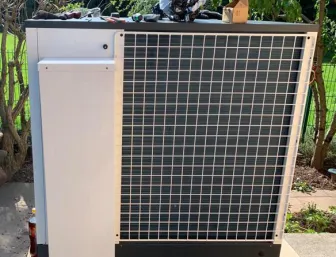 Rückansicht der Heizungsanlage SolvisMia im Garten eines mediterranen Hauses.